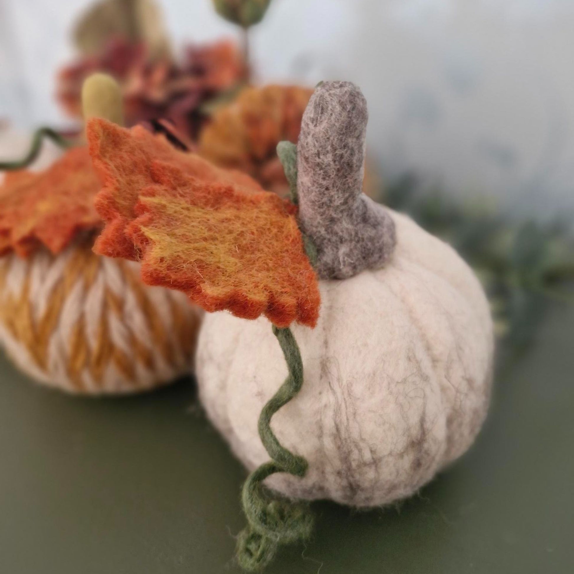 White and grey needle-felted wool pumpkin with leaf and upright stem, 11×11×15cm.