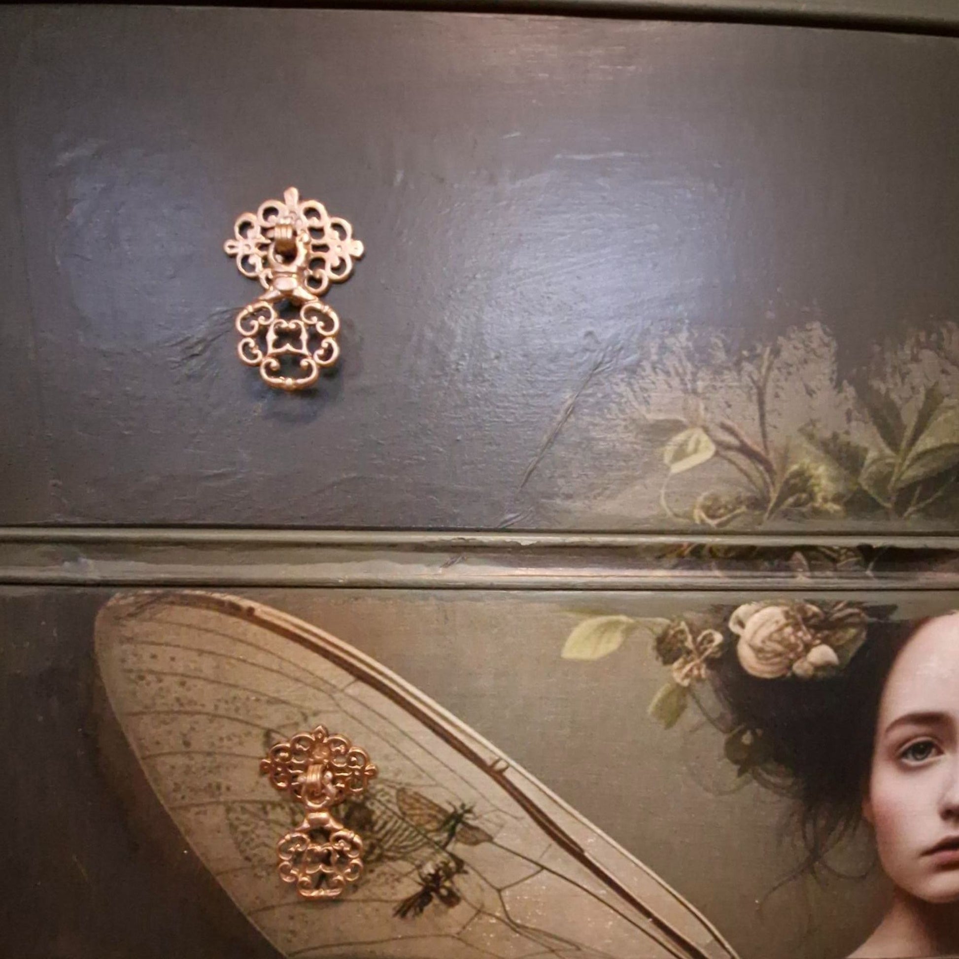 Ethereal fairy decoupage chest in mossy Bayberry with bronze hardware, styled in a calm bedroom setting.