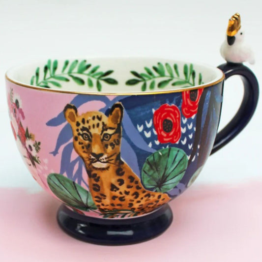 Frida Kahlo tropical porcelain mug with gold parakeet handle, gold signature and leaf print inside.