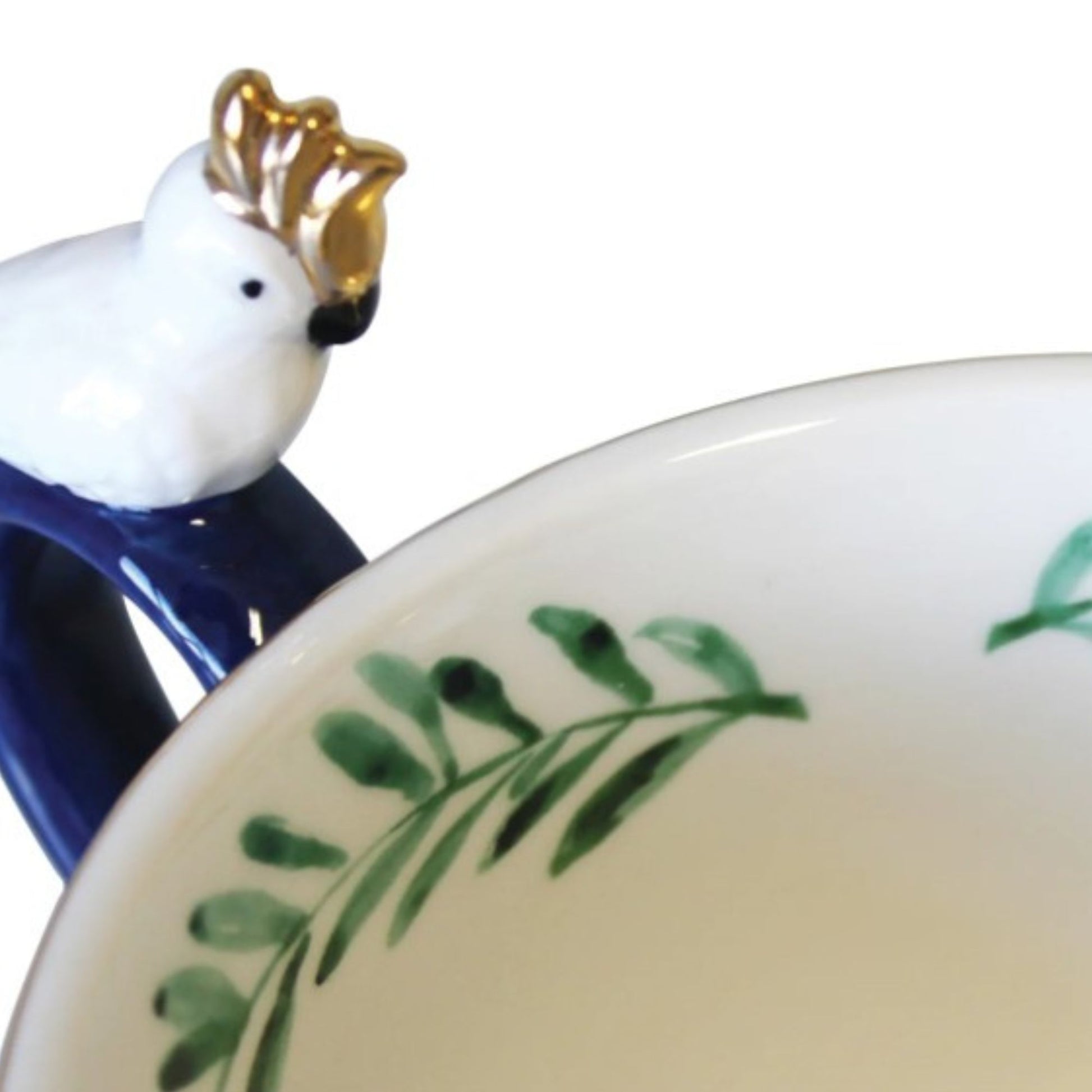 Frida Kahlo tropical porcelain mug with gold parakeet handle, gold signature and leaf print inside.