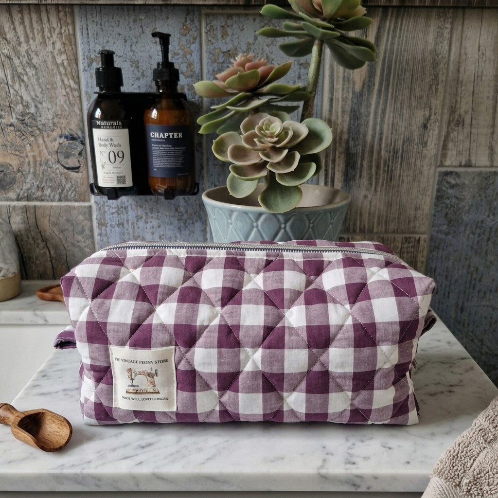 Hair tool bag in plum colourway staged in a vanity unit with lavender hand soap and cactus plant