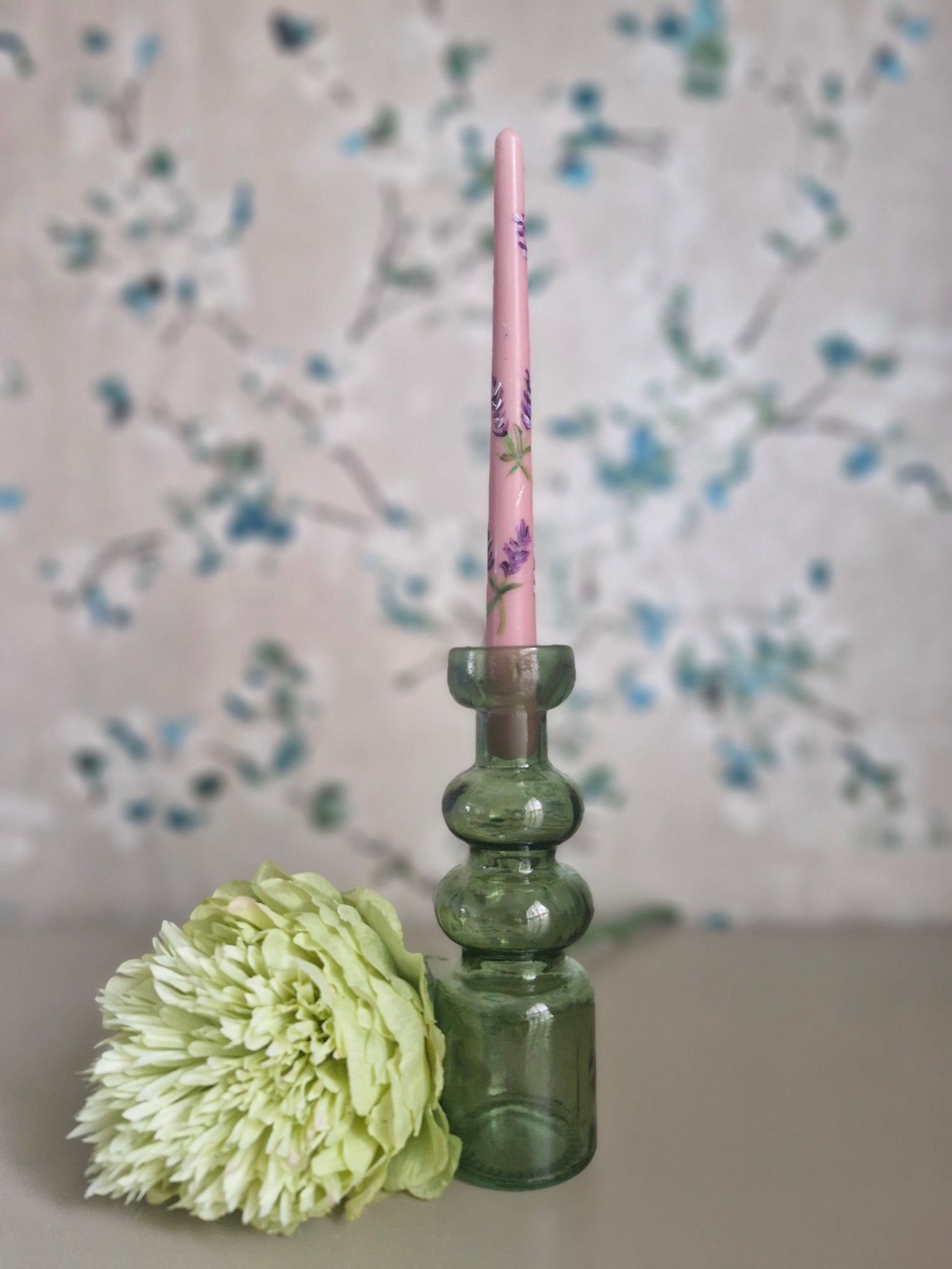 Recycled glass candleholder is designed to hold both dinner candles and tealights. It offers a stylish way to brighten any space. Its unique shape also allows it to double as a charming mini vase for flowers