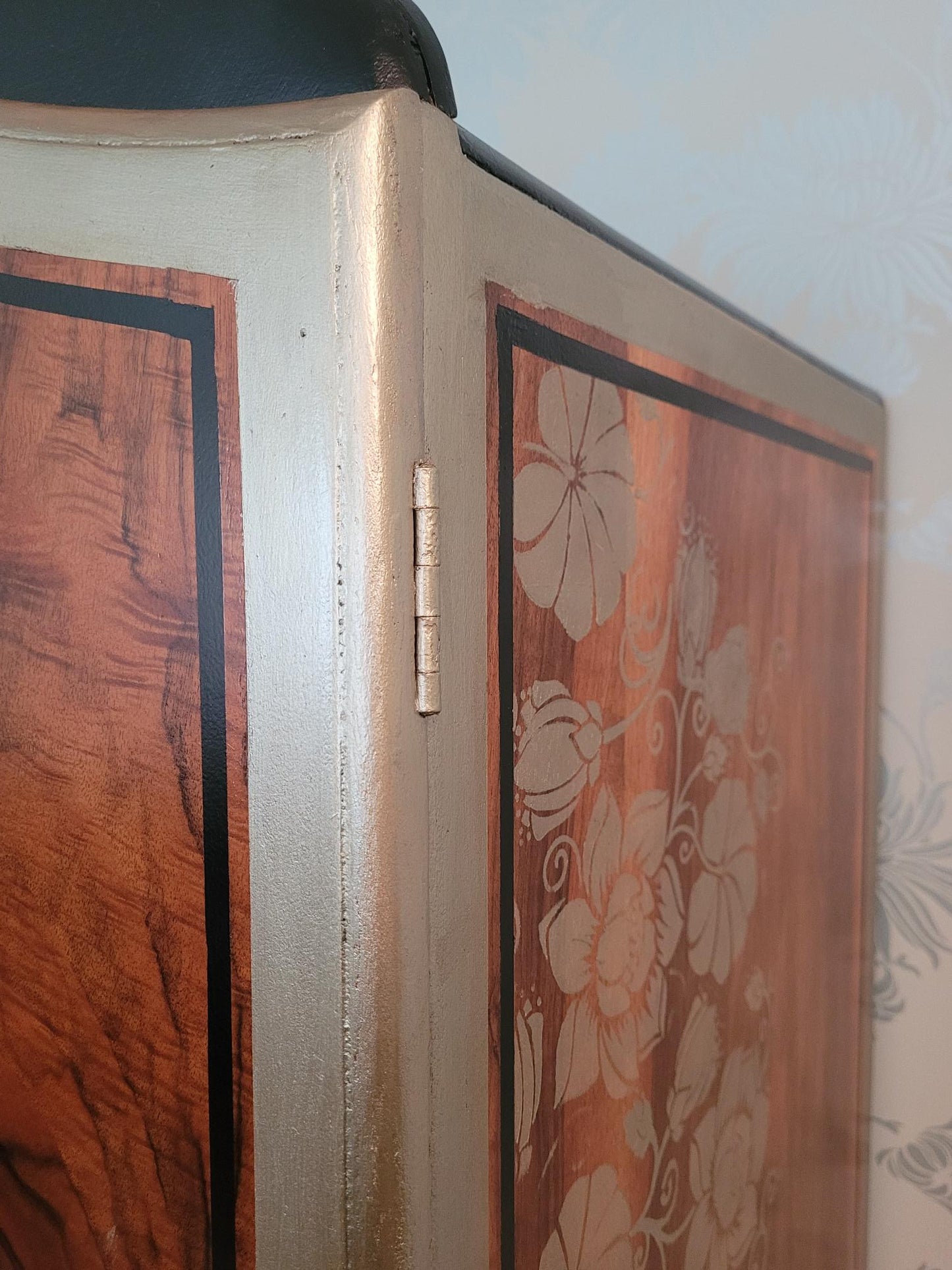 Upcycled Art Deco wardrobe with walnut veneer, black and gold accents, and floral stenciling.