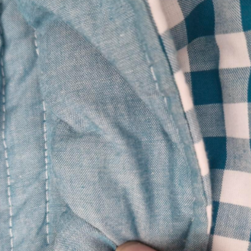 Teal bag close up showing interior stitching.