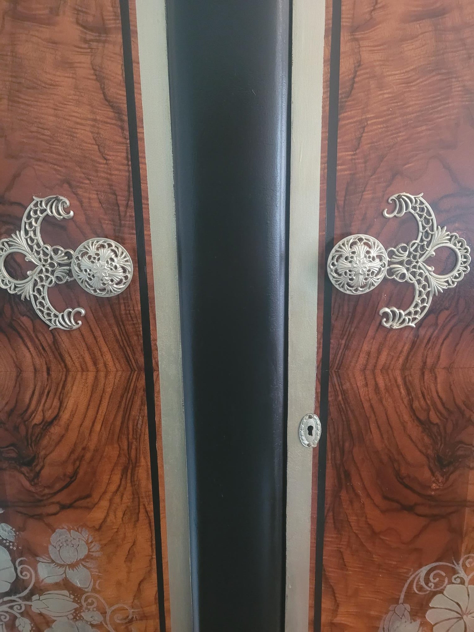 Upcycled Art Deco wardrobe with walnut veneer, black and gold accents, and floral stenciling.