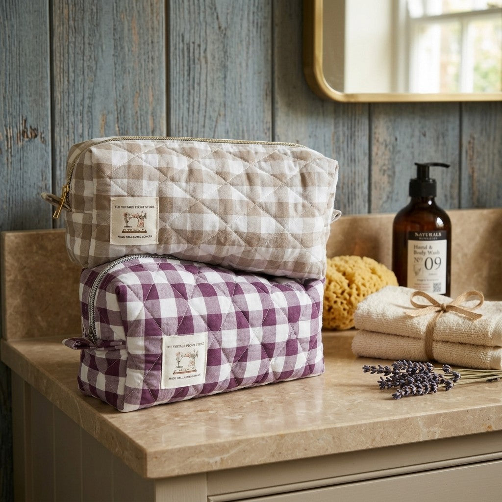 Two quilted pouches stacked on a bathroom counter with soap and lavender.