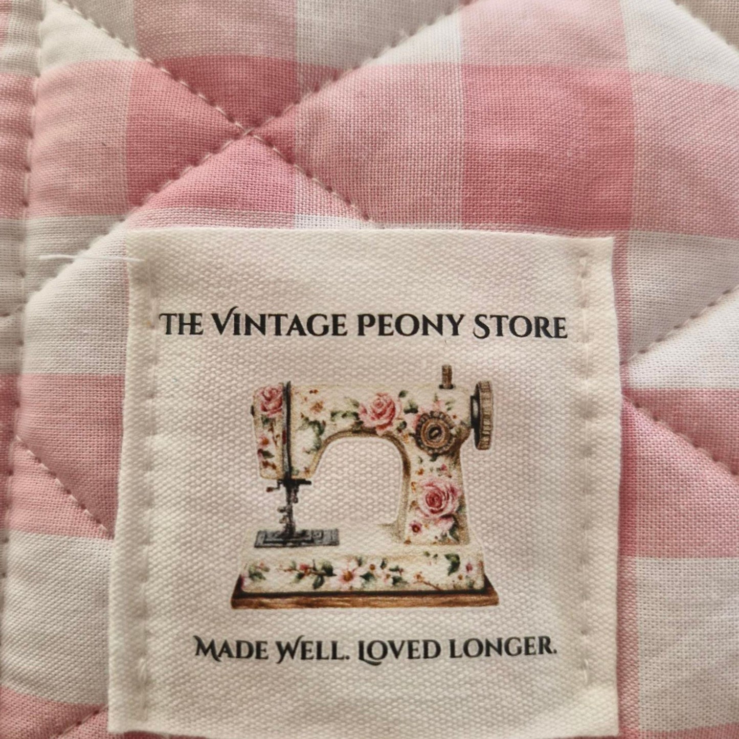 Label from The Vintage Peony Store on a pink and white checkered fabric background