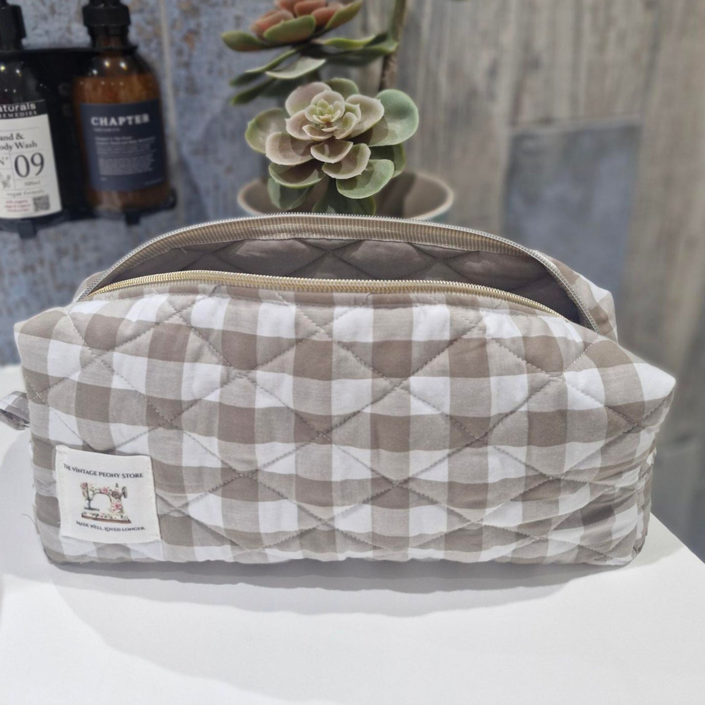 Quilted toiletry bag with checkered pattern on a white surface