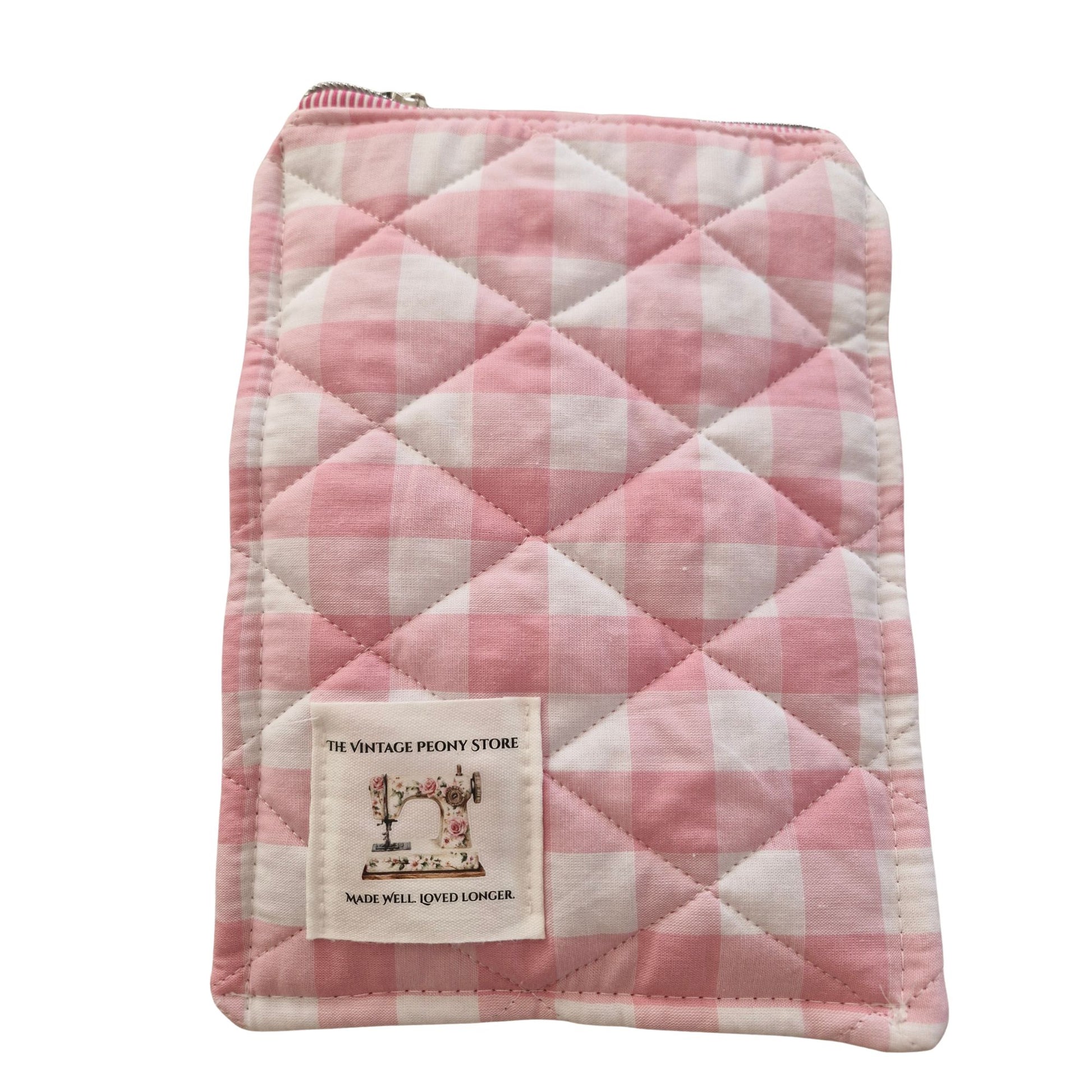 Quilted pink and white checkered pouch with a visible brand label on a white background
