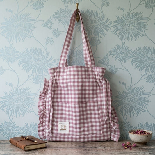 Pink Gingham Tote bag on a wooden shelf with notebook and pot of pot pouri.