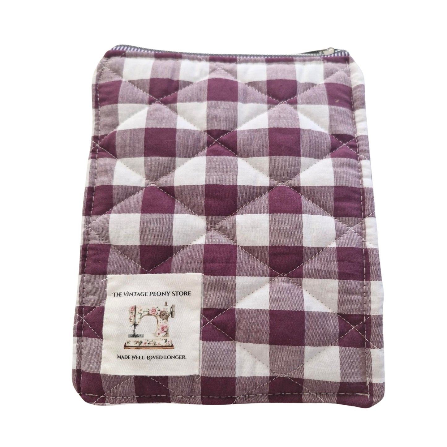 Quilted fabric with plum and white checkered pattern on a white background
