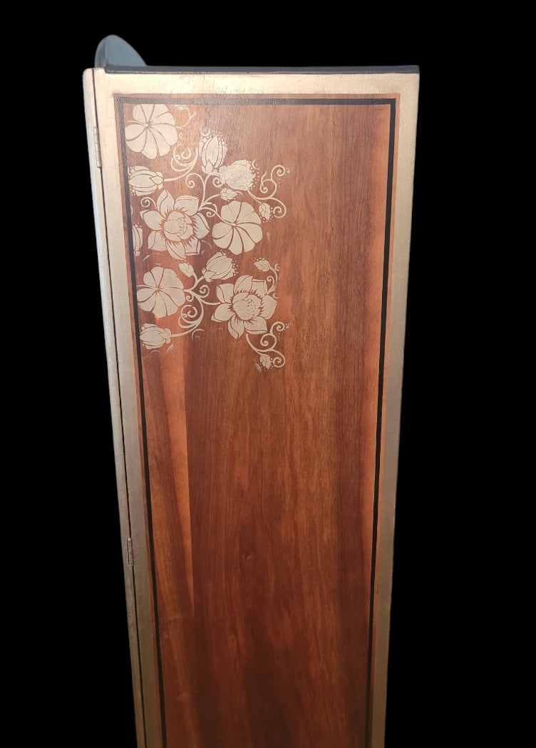 Upcycled Art Deco wardrobe with walnut veneer, black and gold accents, and floral stenciling.