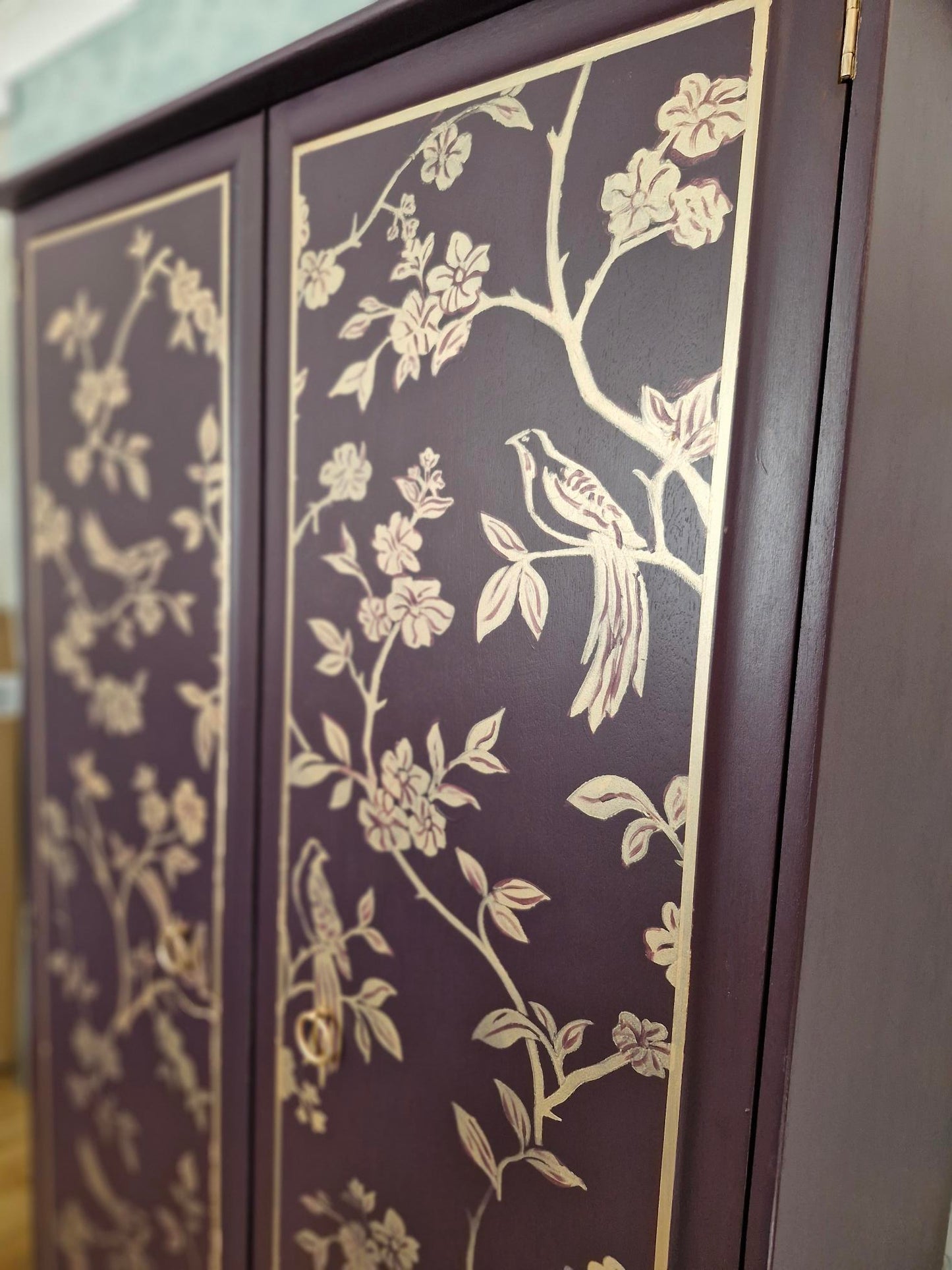 close up image of a gold chinoiserie detail on the wardrobe door