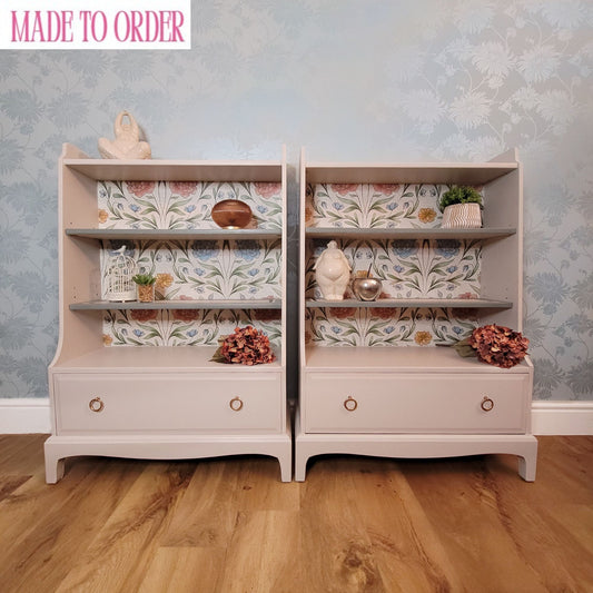 Beautifully upcycled cream bookshelf with floral wallpaper backing painted in Fusion Mineral Paint, Cashmere. The shelves display decorative items and the bottom drawer features elegant gold ring pulls. Perfect for adding a touch of nature-inspired charm to any living room, bedroom, or hallway.