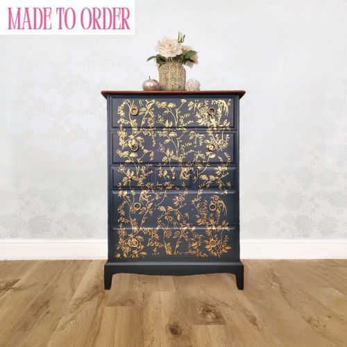 Elegant upcycled navy blue chest of drawers featuring a delicate, hand-painted gold floral design. The drawers are accented with intricate gold knobs, making this piece a sophisticated addition to any living room, bedroom, or hallway.