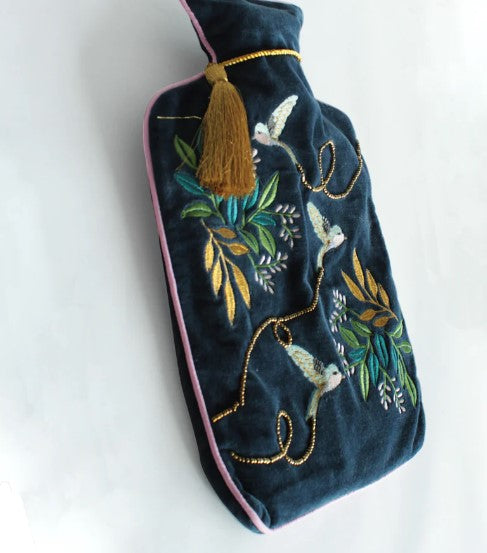 Dark blue velvet hot water bottle cover with embroidered swallows, gold stitching, pink piping and tassel