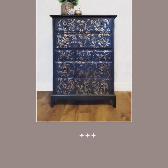 Elegant upcycled navy blue chest of drawers featuring a delicate, hand-painted gold floral design. The drawers are accented with intricate gold knobs, making this piece a sophisticated addition to any living room, bedroom, or hallway.